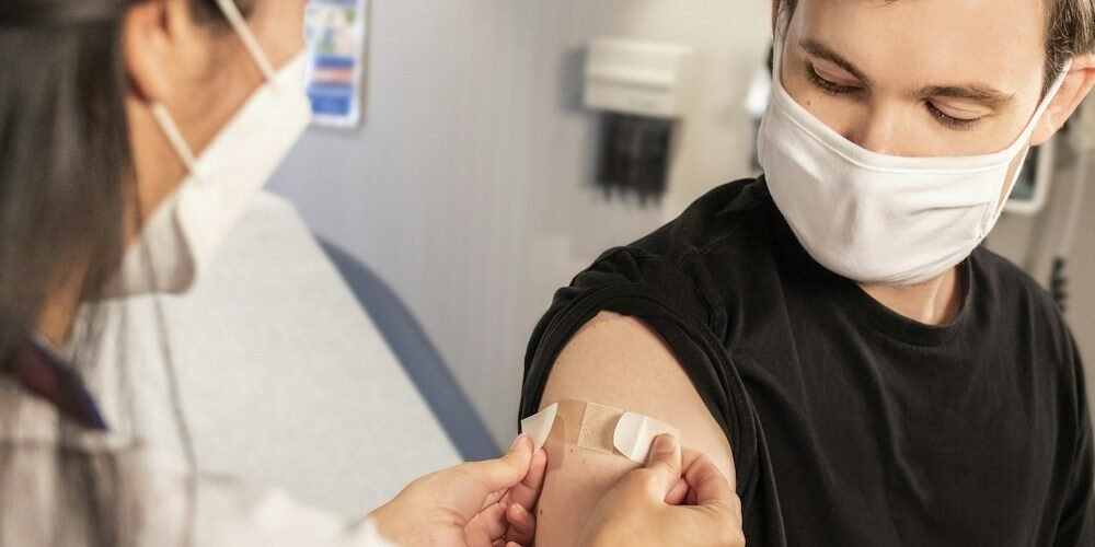 Healthcare provider applying a bandage after influenza vaccination in a clinic