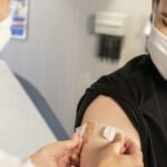 Healthcare provider applying a bandage after influenza vaccination in a clinic