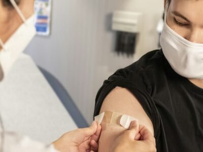 Healthcare provider applying a bandage after influenza vaccination in a clinic