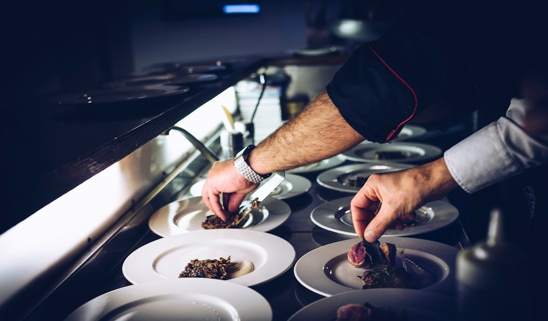 Chef carefully plating a fine dining dish for restaurant guests
